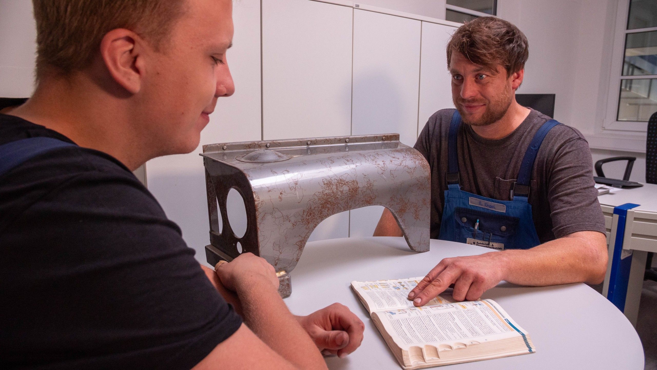 Meister erklärt Lehrling theoretische Arbeit an Karosserie