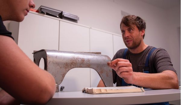 Theoretische Lehrstunde im Betrieb - Meister erklärt Auszubildendem etwas